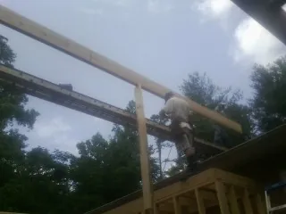 Carpenter setting a ridge beam over a new addition frame — Ice Dam Removal by Roofing Brothers in New Stanton