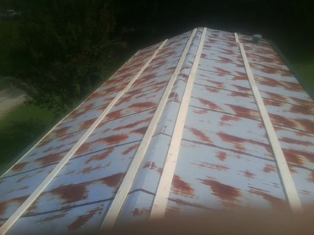 Rusted metal roof panels with new wood purlins before replacement — Storm Damage Roof Repair in New Stanton by Roofing Brothers