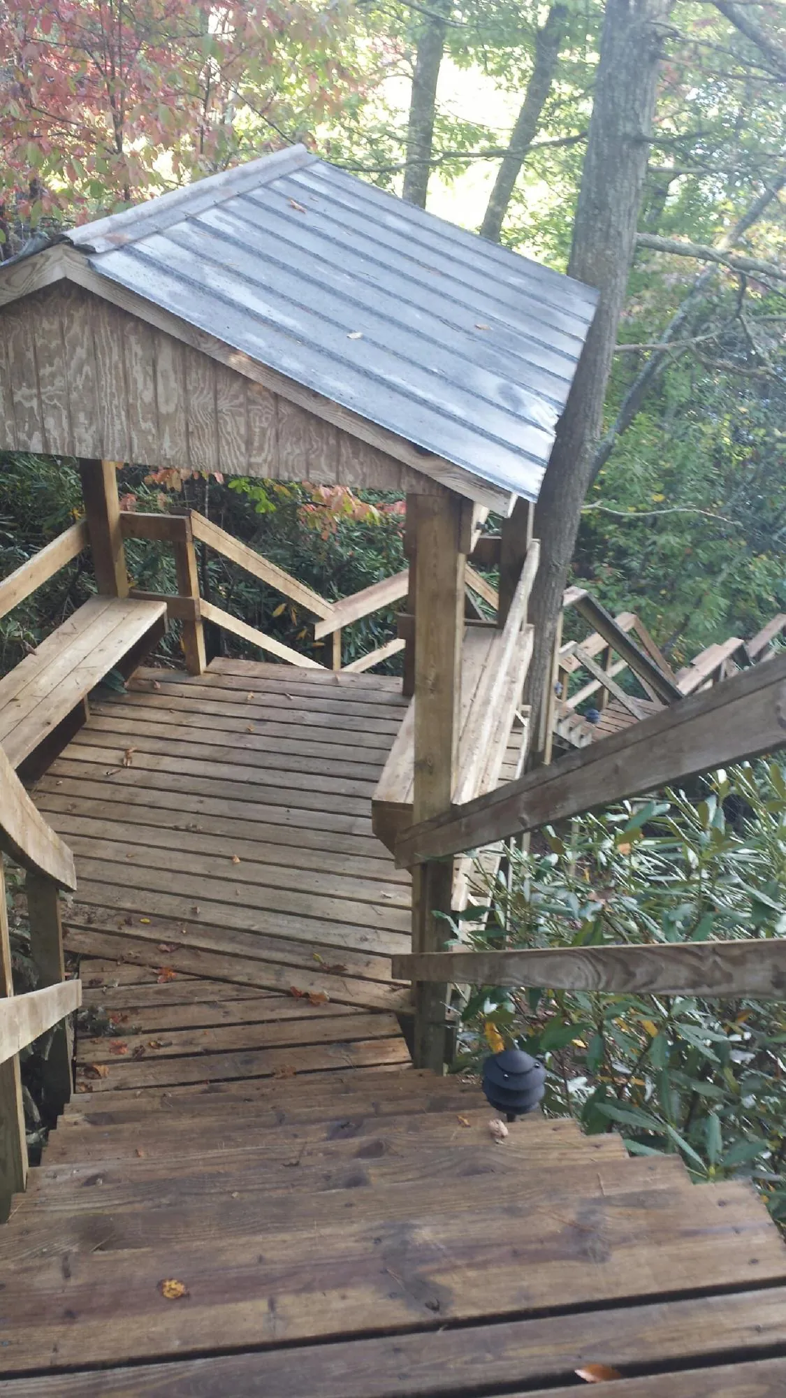 Metal roofed shelter over wooden steps on a wooded walkway — Skylight Repair & Installation work by our crew in New Stanton