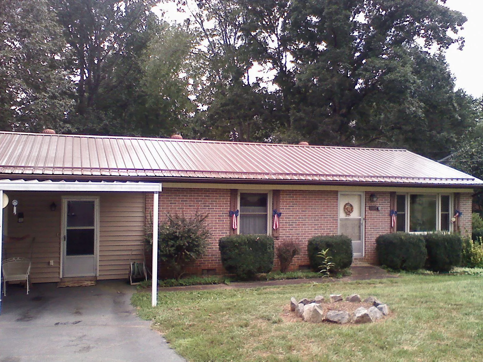 Bronze metal roof and carport on a brick ranch home — Roof Repair work by our crew in New Stanton