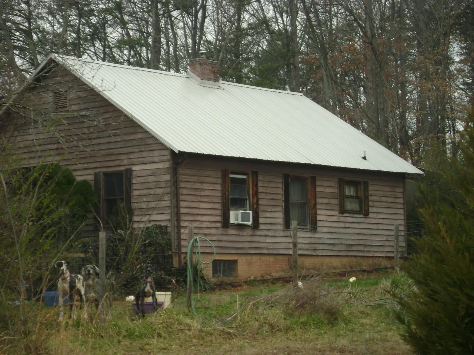 White metal roof on an old wood sided farmhouse, from a Asphalt Shingle Roof Repair job in New Stanton